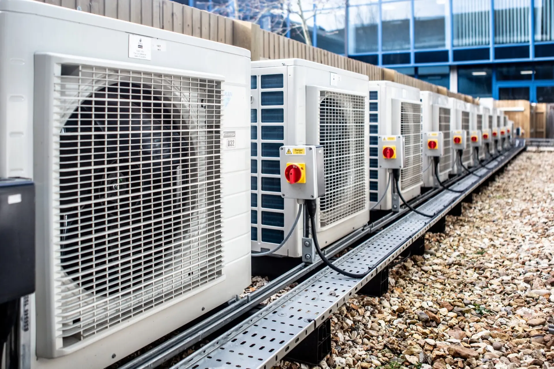 Row of commercial air conditioning condenser units on an industrial rooftop